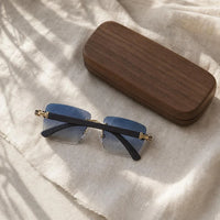 Grove Rimless Sunglasses flat lay with wooden case